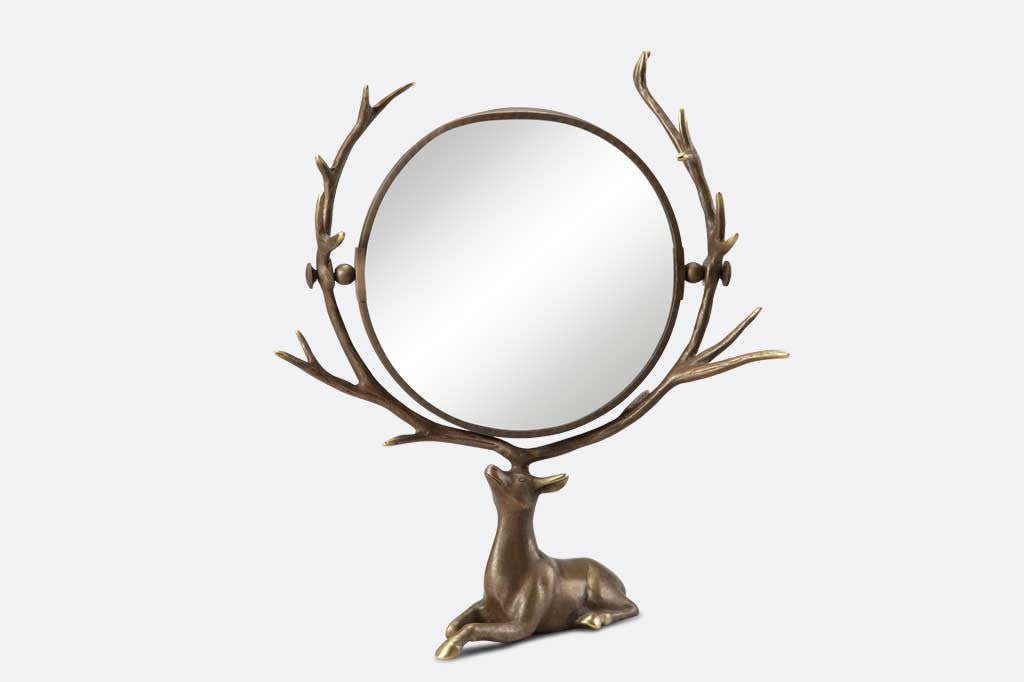 vanity mirror supported by resting deer whose antlers frame the mirror