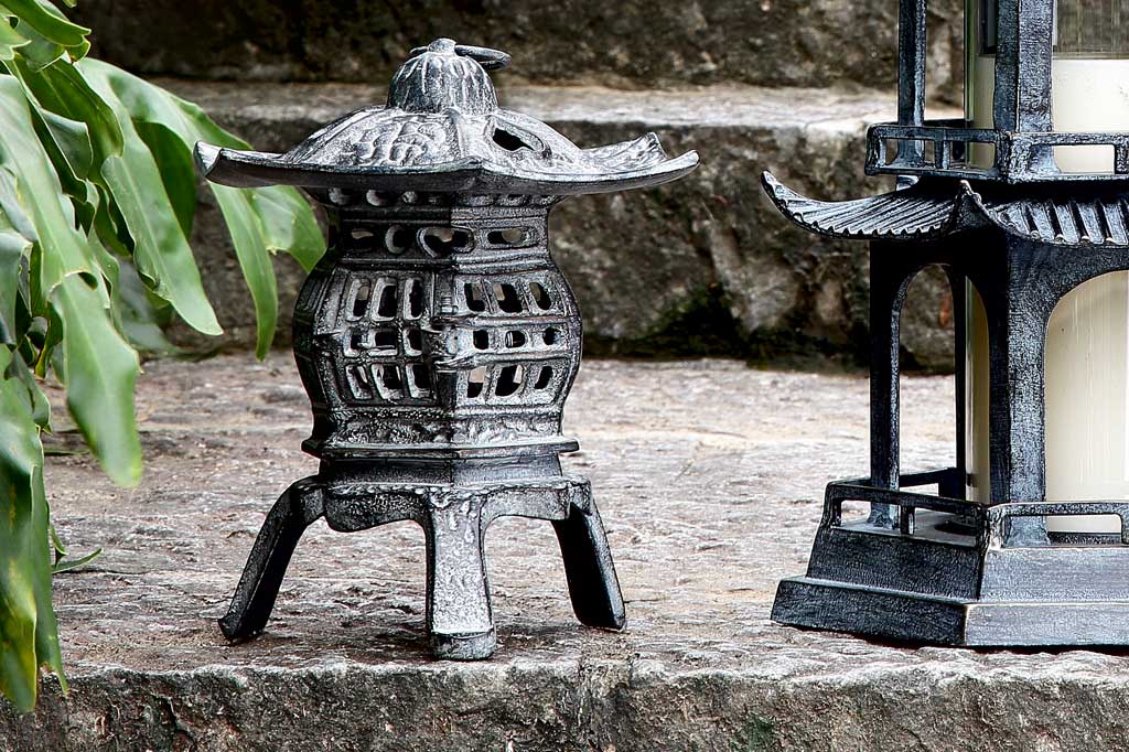cast metal lantern with lit candle inside