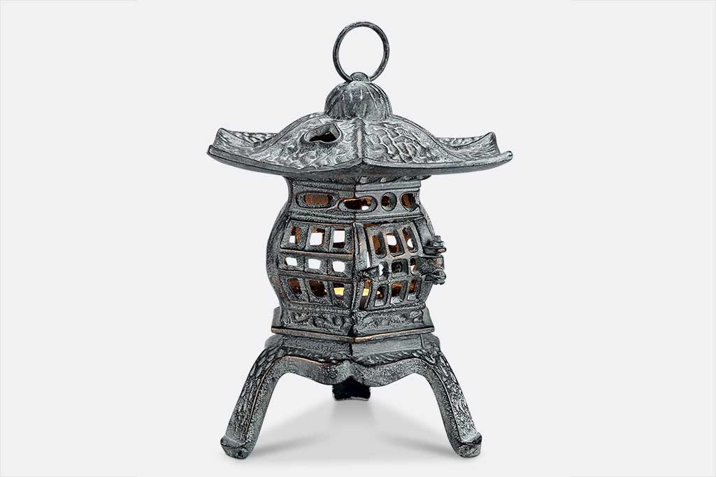 cast metal lantern with lit candle inside