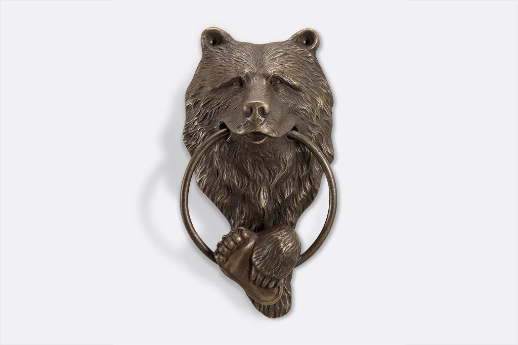 cast metal bear door knocker with the ring inside the bears mouth