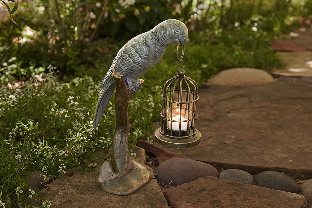 cast metal parrot seating on branch holding birdcage with tealight sculpture
