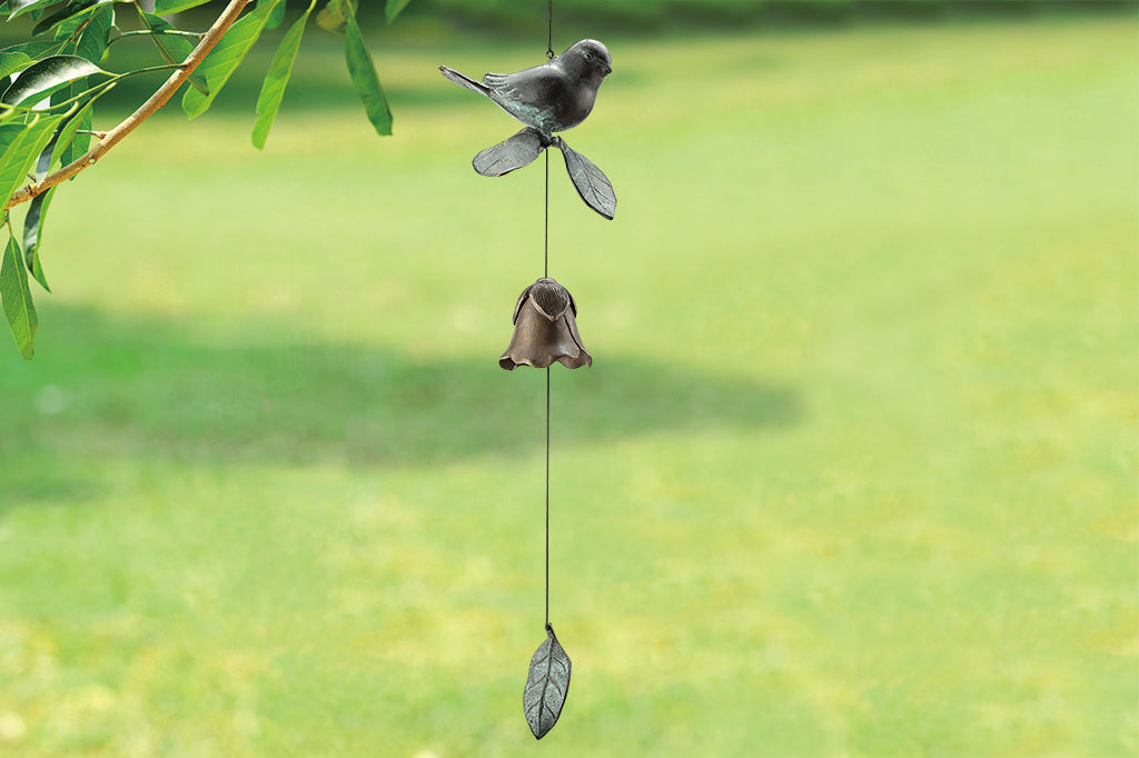 Cast brass bird and blossom shaped bell wind art