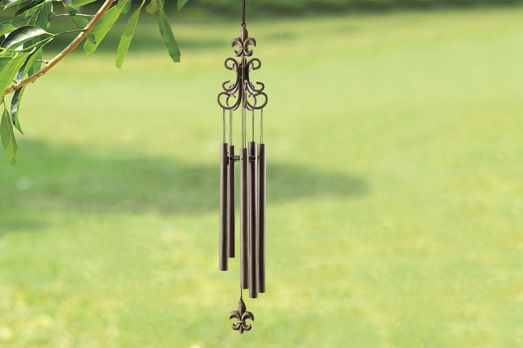 Fleur de Lys motif on tall wind art shown outside by tree