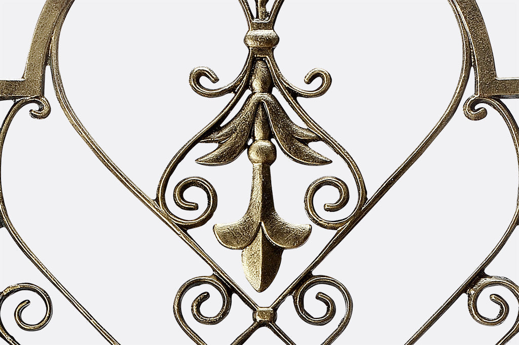 closeup of garden trellis in bronze with fleur de Lys and scrollwork motifs