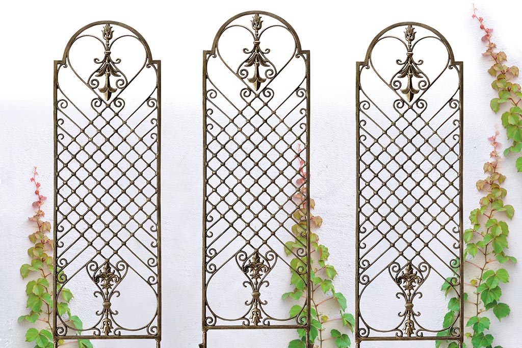 3 garden trellis against garden wall in bronze with fleur de Lys and scrollwork motifs