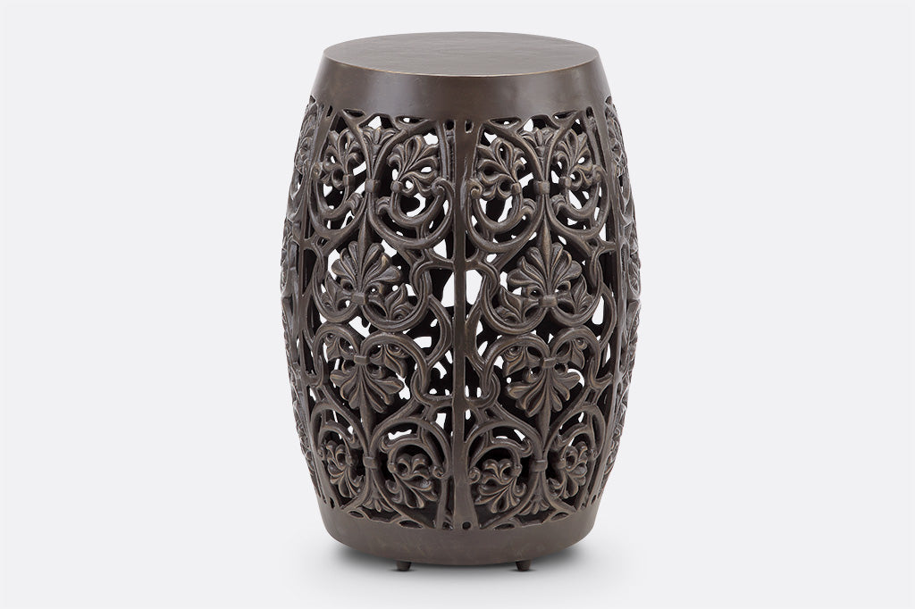 Elaborate floral scrollwork around a garden stool, solid top and peg feet
