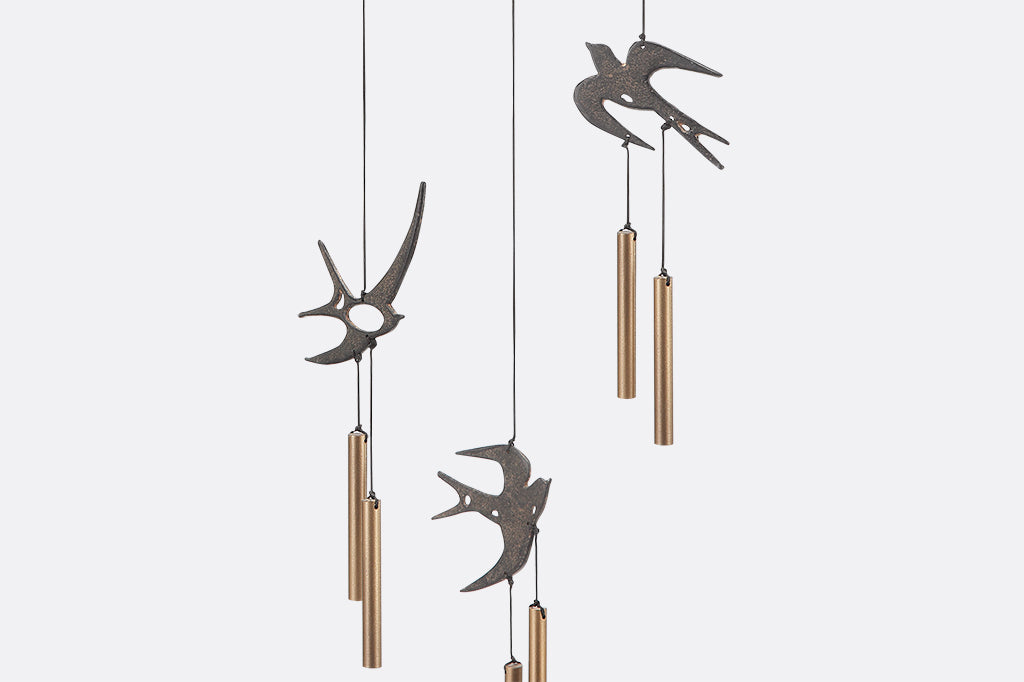 Circular Ring has three swallows and chimes suspended from it as wind art - closeup of swallows