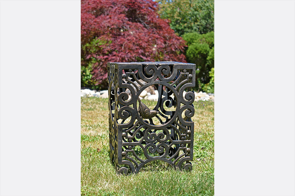 Rectangular stool featuring Capistrano scrollwork and swallow bird sculpted in circular opening, shown in garden setting
#color_Espresso Bronze