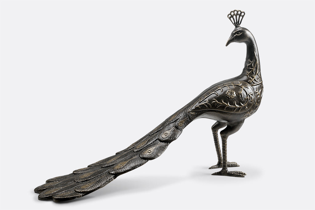 cast metal peacock bird bath, with feathers creating the base of the bird bath