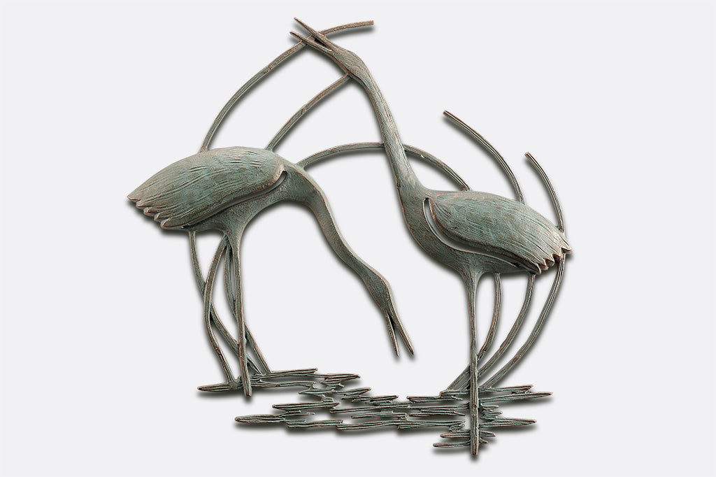Wall plaque of two cranes standing in reeds and water
