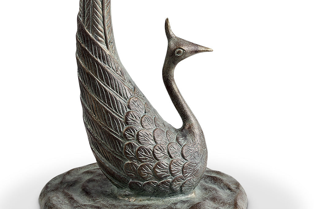 cast metal peacock bird bath, with feathers creating the base of the bird bath