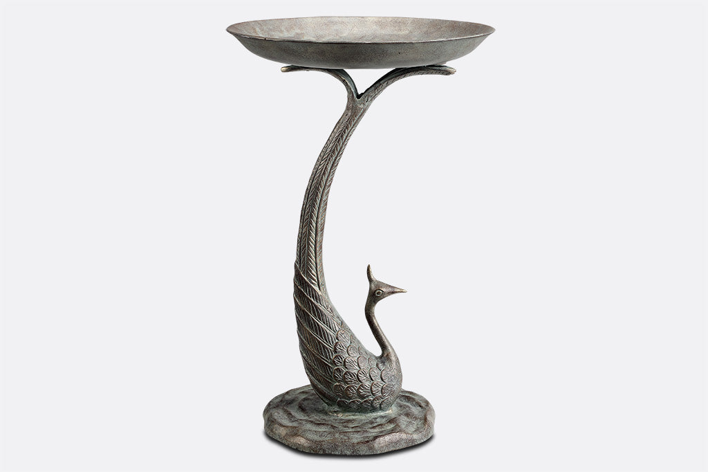 cast metal peacock bird bath, with feathers creating the base of the bird bath