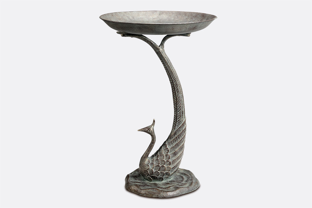 cast metal peacock bird bath, with feathers creating the base of the bird bath