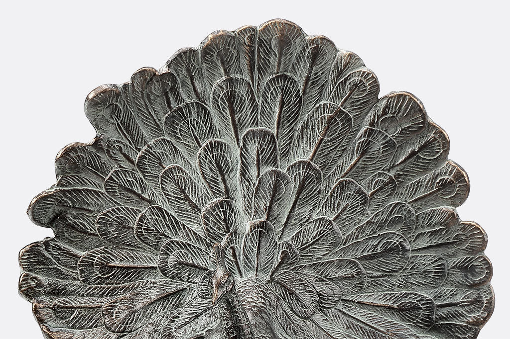 cast metal peacock with feathers fanned out