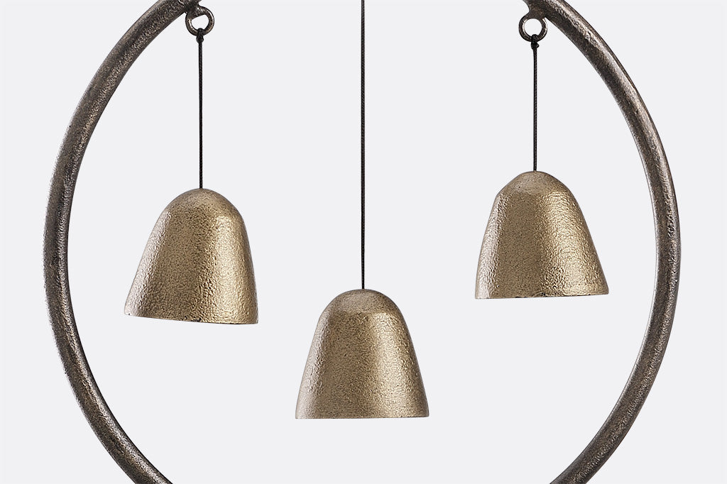 close up view of cast aluminum trio of wind bells
