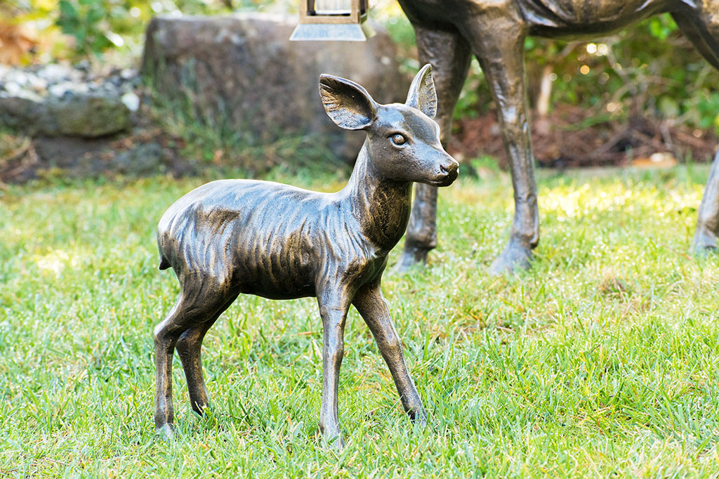 cast metal fawn sculpture placed on green lawn