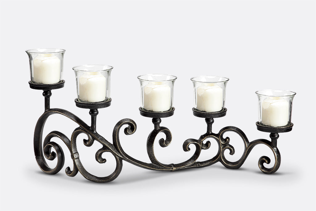 classic scrollwork design on table candelabra that holds 5 candles in glass cups
