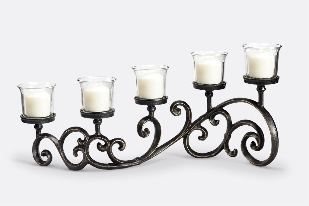 classic scrollwork design on table candelabra that holds 5 candles in glass cups