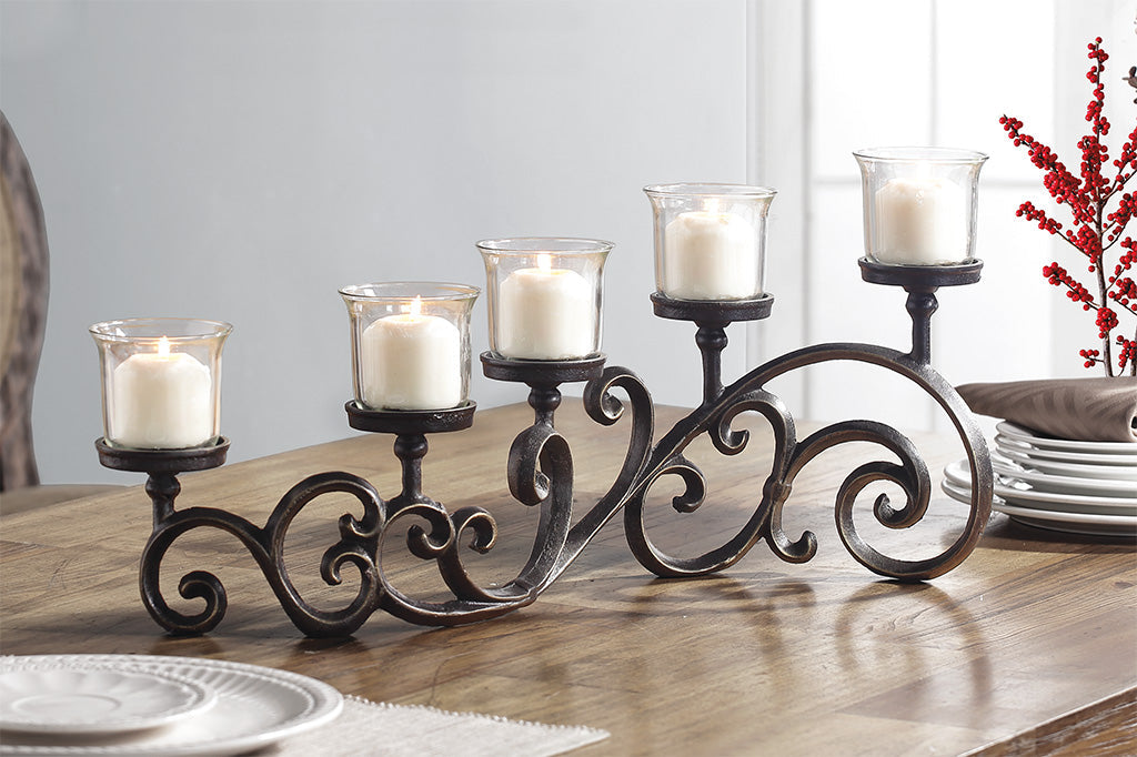 classic scrollwork design on table candelabra that holds 5 candles in glass cups