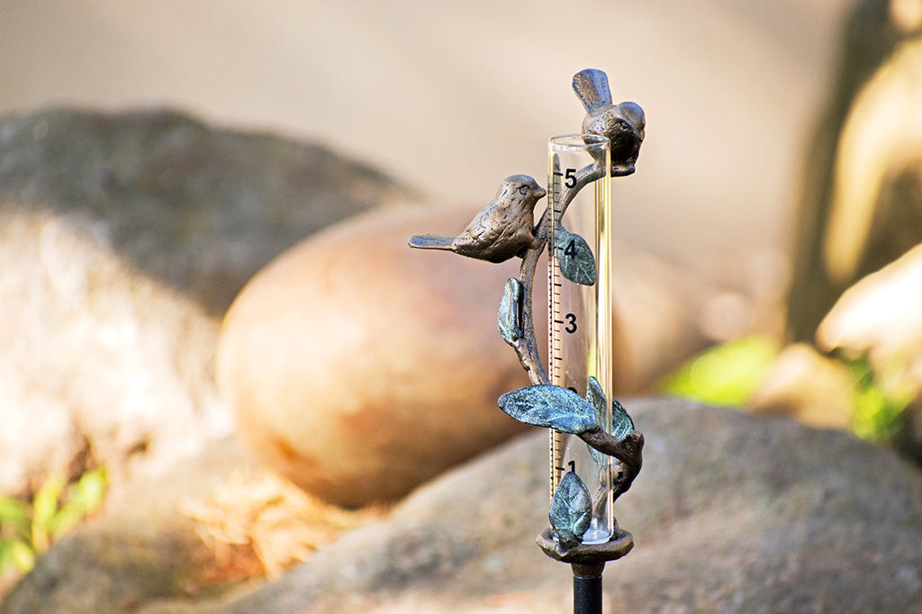 cast metal branch and bird rain catcher in garden scene