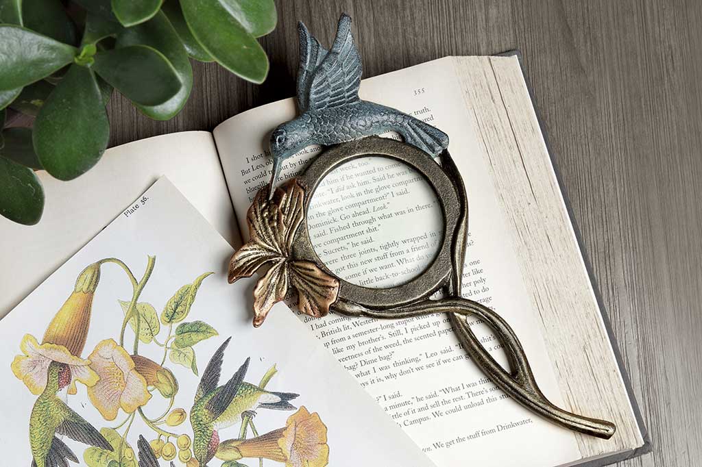 handheld magnifying glass with flower and hummingbird motif