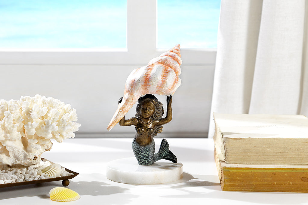 desk sculpture of kneeling mermaid holding pink shell over her head