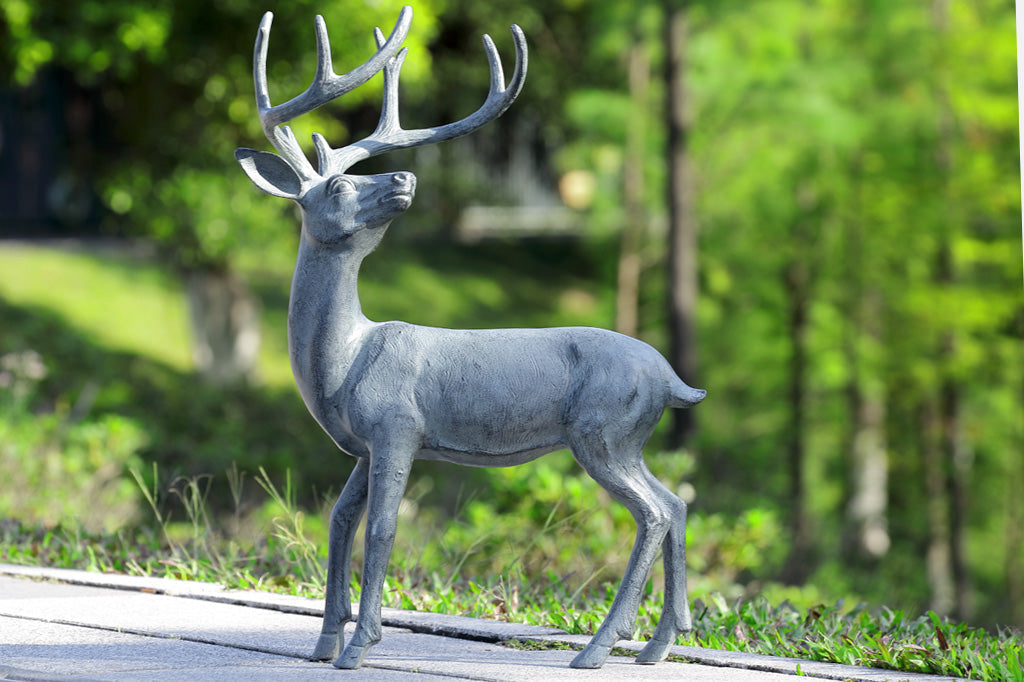 deer with antlers garden sculpture, cast metal set on roadside