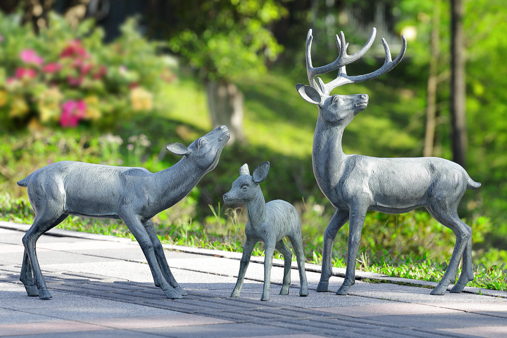 family of three deer cast metal sculptures on roadside