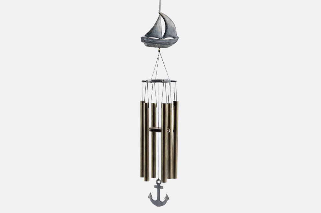 Wind chime with cast metal sail boat motif in zinc finish has 6 tube chimes and a pendant shaped like an anchor