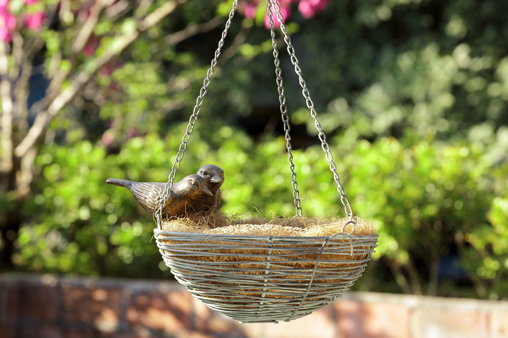 hanging plant basket shaped like nest with two sparrow perched - shown with coco liner in garden