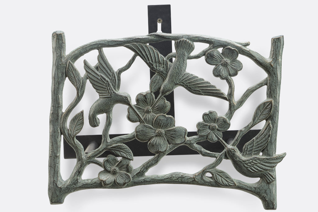 bird and dogwood branches adorn a wall-mounted garden hose holder
