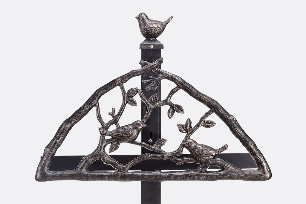 close up detailing of bird finial, and the two birds sitting on branches