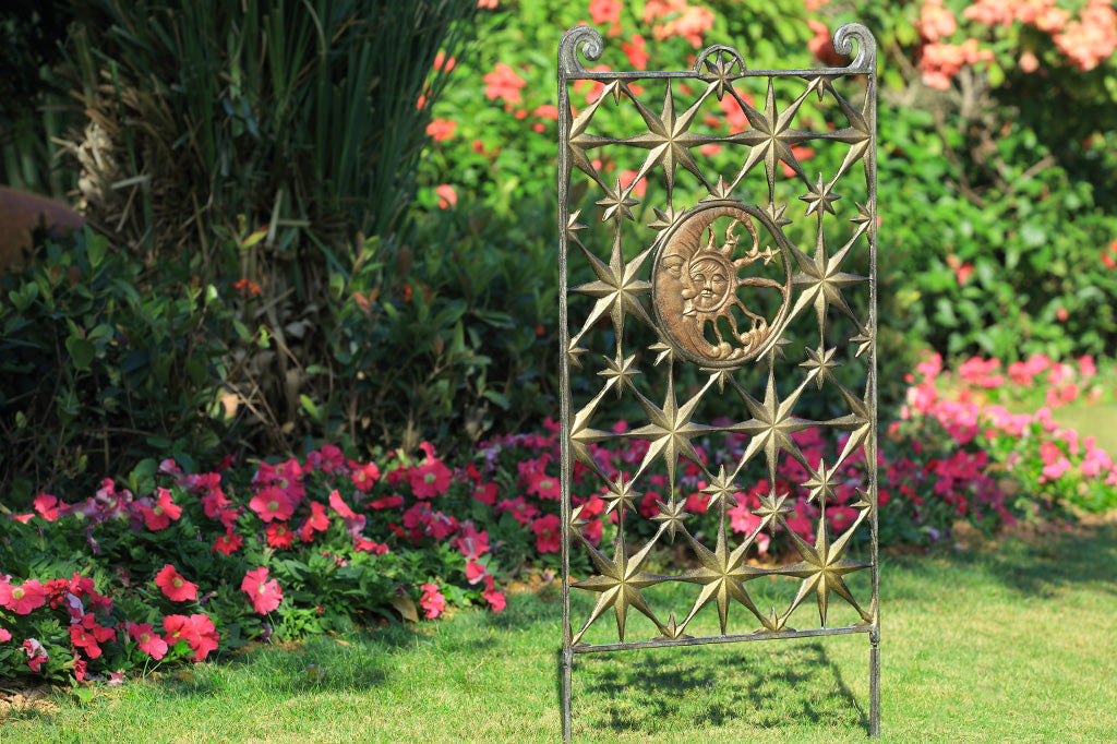 garden trellis features stars and celestial theme medallion of sun and moon - shown in garden on grass with floral background
