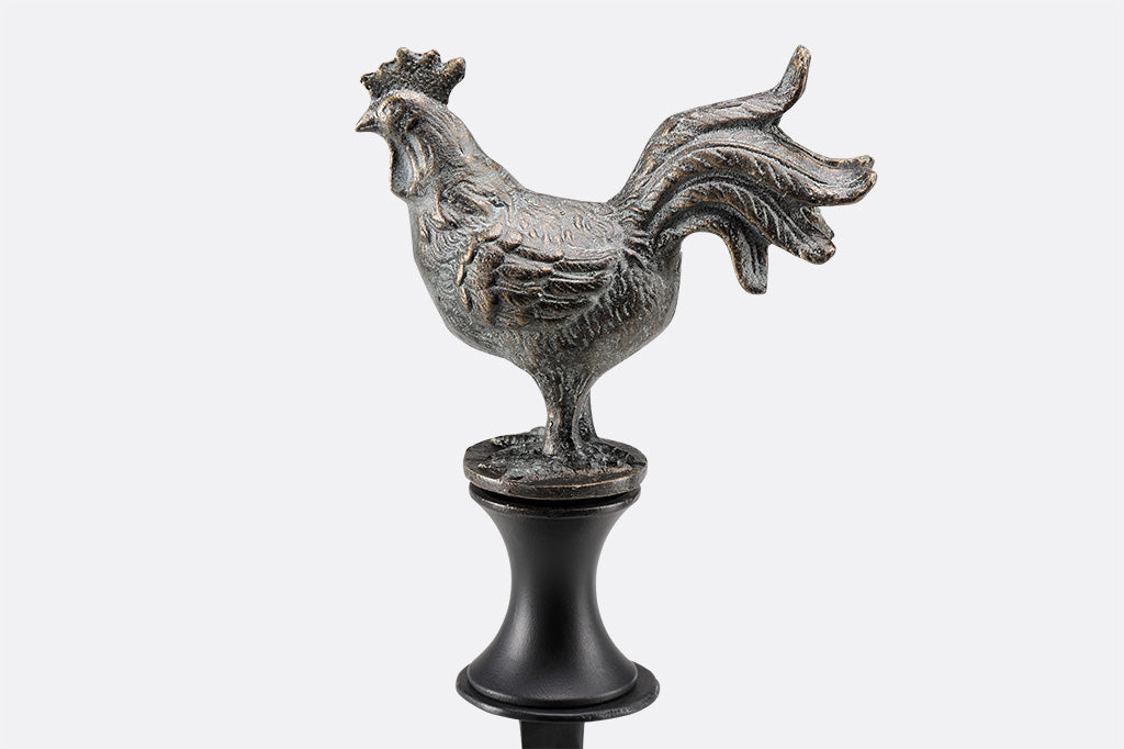 rooster shaped bronze finish hose guard shown with grass and hose