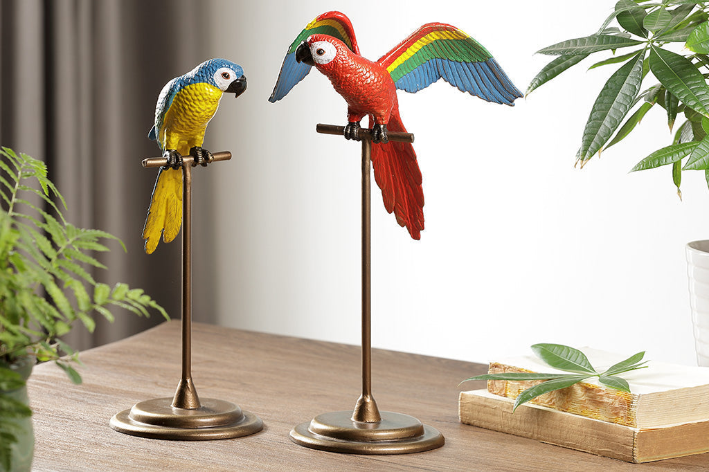 red parrot with rainbow wings, on metal base next to blue and yellow parrot