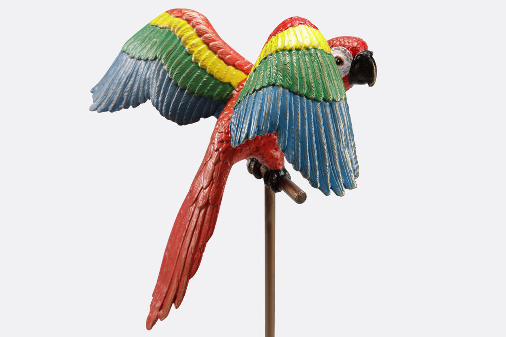 red parrot with rainbow wings, on metal base