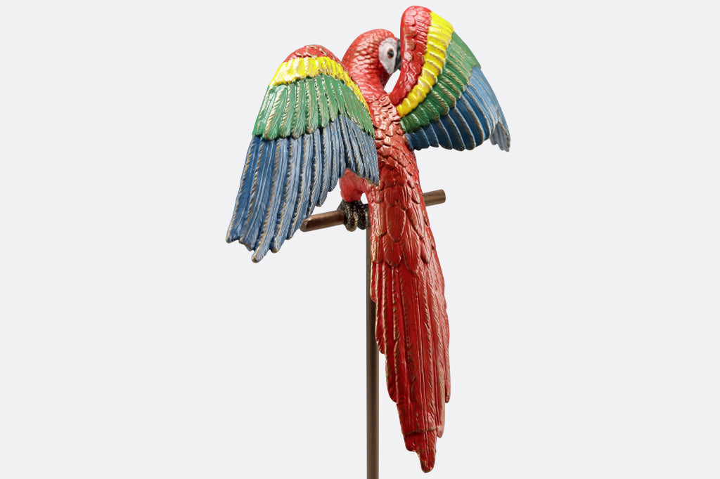 red parrot with rainbow wings, on metal base