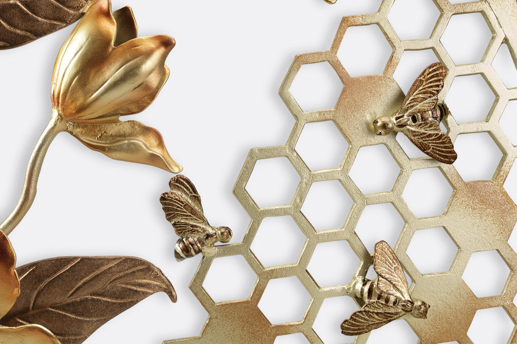 close up view of sculpted bees, honeycomb, and blossom
