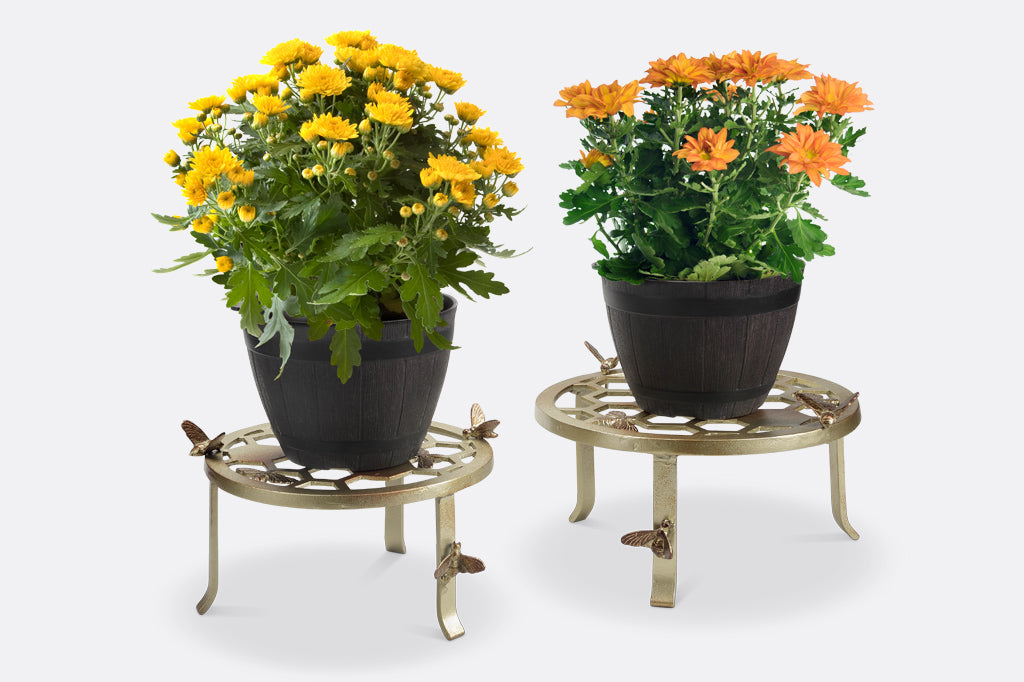 Two plant stands showing honeycomb and bee motif, one large and one small, shown with potted plants
