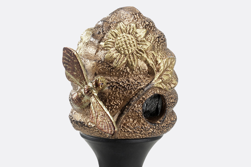cast metal beehive with sunflower and bee hose guard