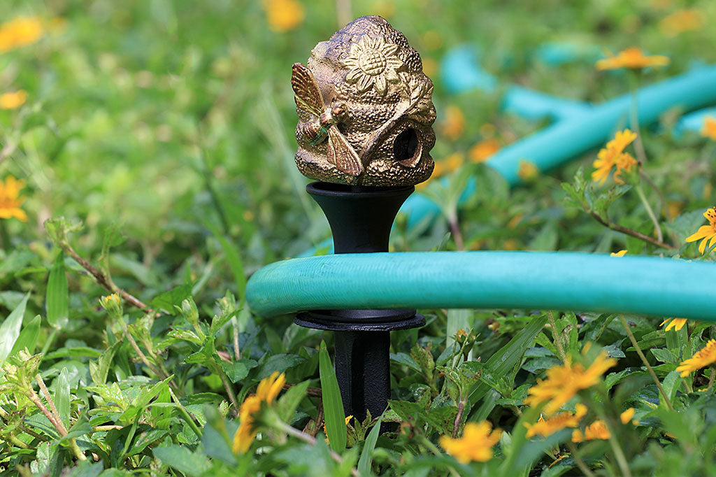 cast metal beehive with sunflower and bee hose guard