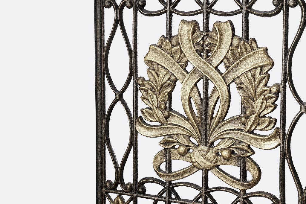 rectangle cast metal garden trellis with golden wreath in center as accent detailing