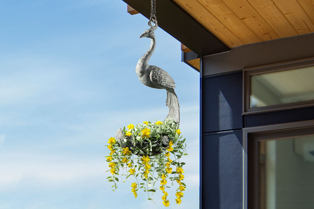 hanging sculptural planter with peacock shape shown hanging from roof and filled with flowers