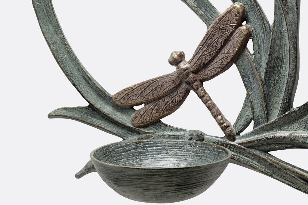 closeup view of feeding bowl on outdoor bird feeder with dragonfly motif