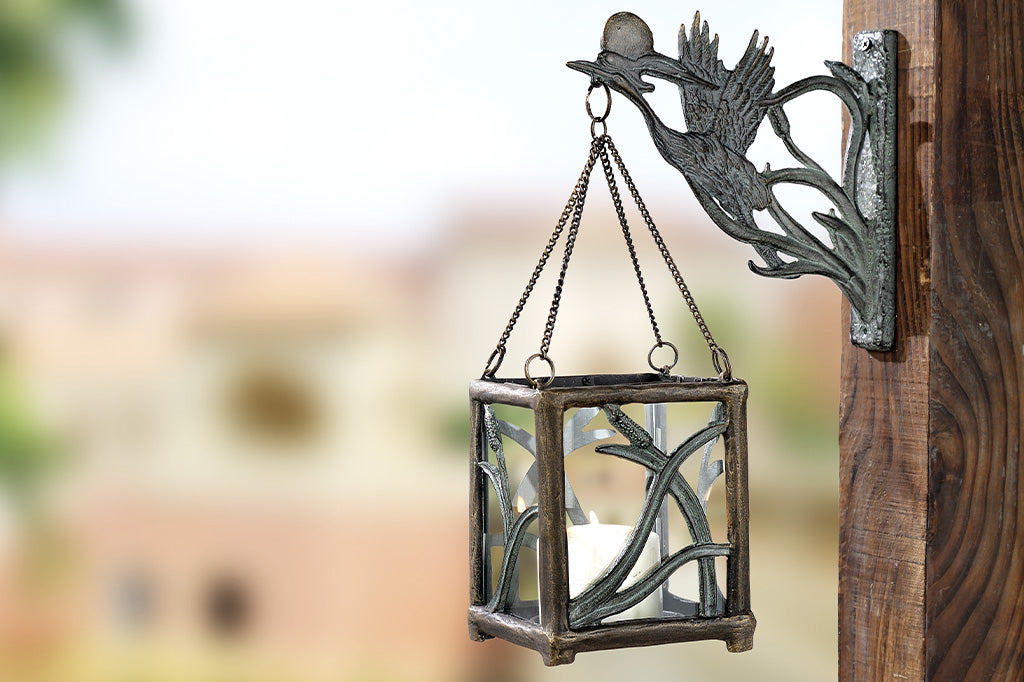 Asian style cast metal hanging candle lantern features crane, setting sun, and cattails