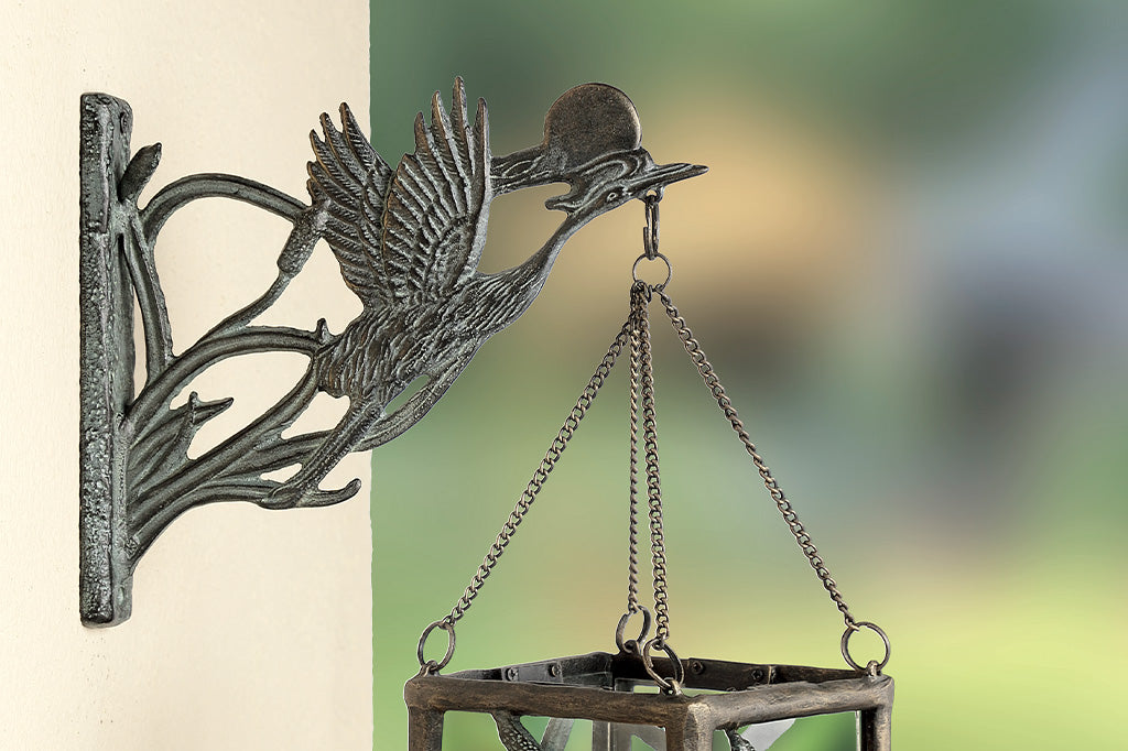 Asian style cast metal hanging candle lantern features crane, setting sun, and cattails