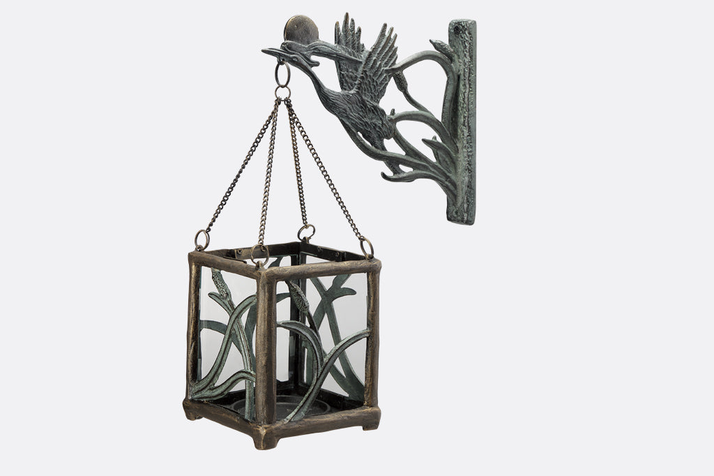 Asian style cast metal hanging candle lantern features crane, setting sun, and cattails