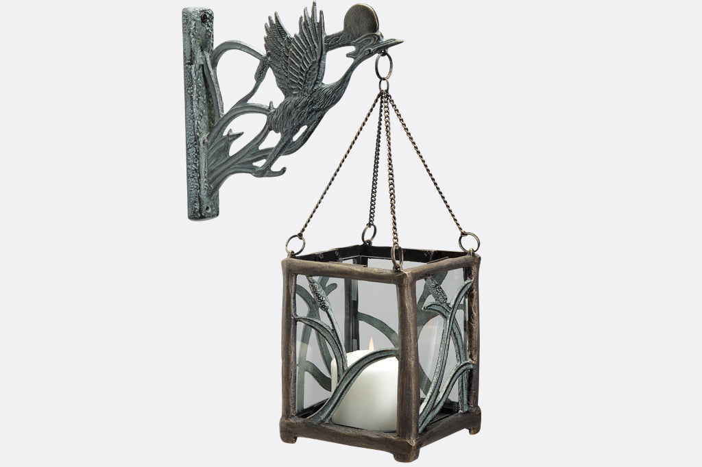 Asian style cast metal hanging candle lantern features crane, setting sun, and cattails