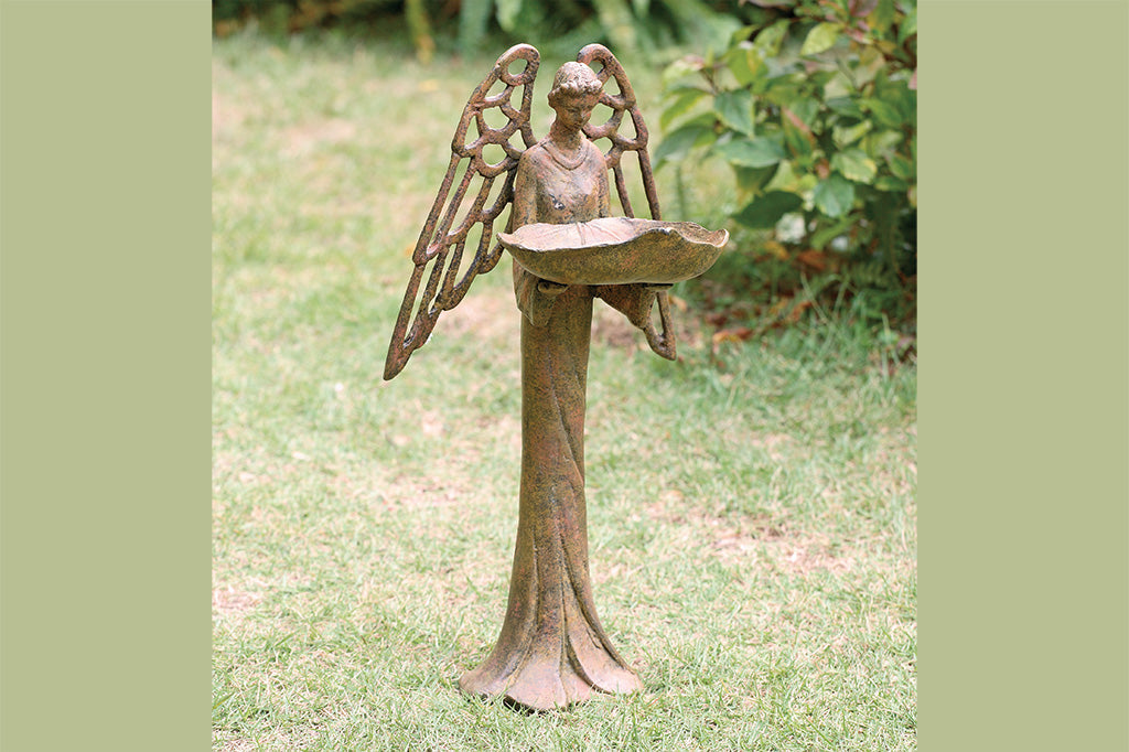 cast metal angel bird feeder with red and orange highlights in garden 
