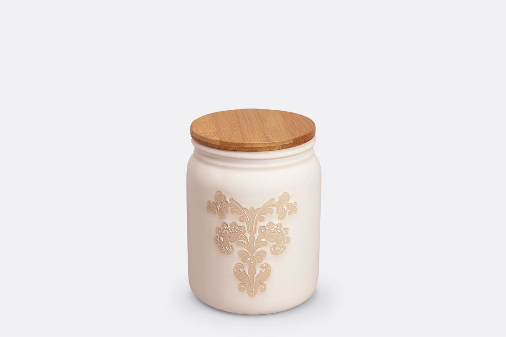 White ceramic vessel with blush on white, lace-inspired embossed design shown on canister with bamboo lid